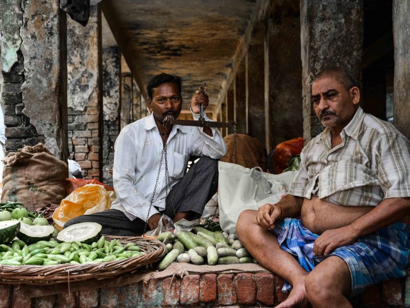 Due uomini vendono ortaggi al mercato di Varanasi in India