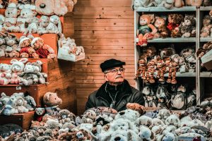 Vienna, Austria. Uomo immerso nella sua casetta di pupazzi in vendita