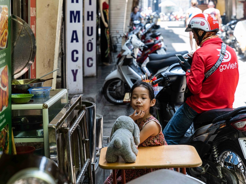 Bambina gioca nelle strade di Hanoi in Vietnam