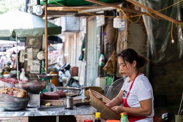 Ragazza vende prodotti per le strade di Hanoi in Vietnam