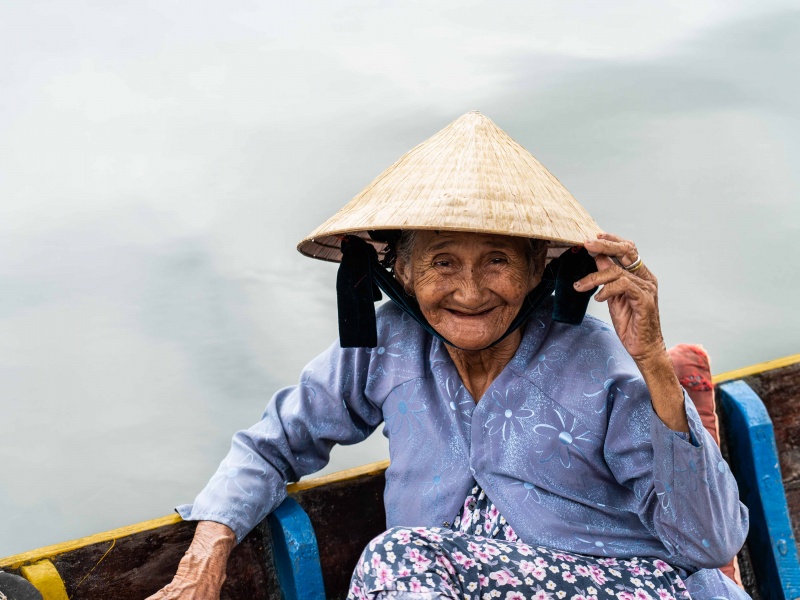 Signora sorridente nel canale di Hoi An in Vietnam